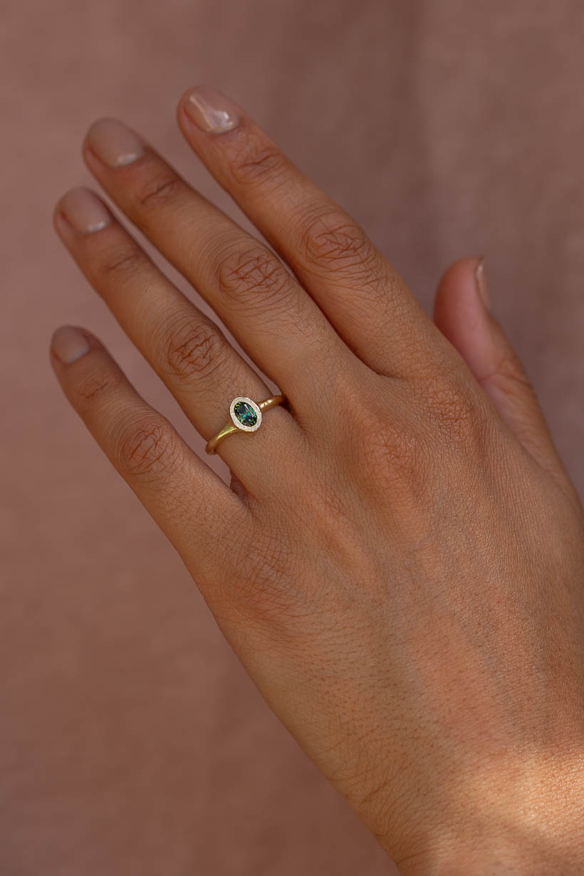 Hand wearing the Bower Ring in gold with a green Australian sapphire