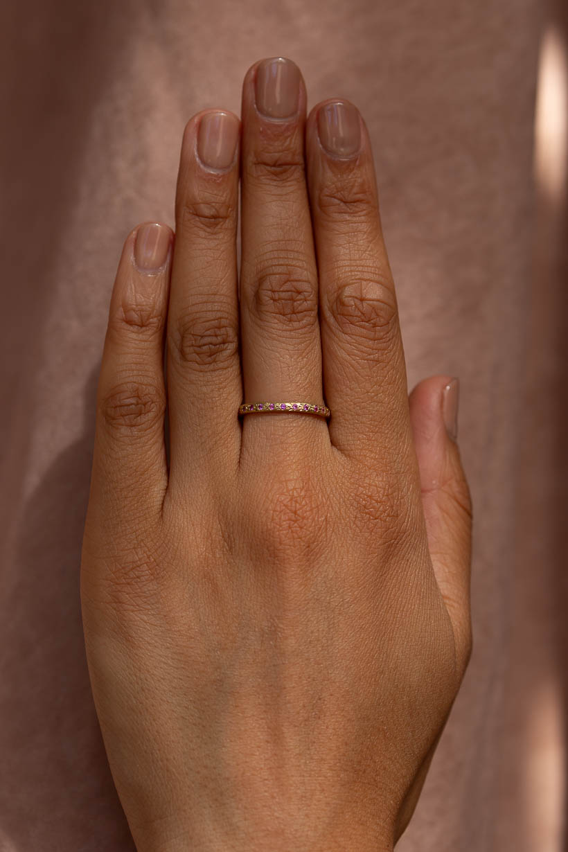 Hand wearing the Rosette Ring in yellow gold with pink sapphires
