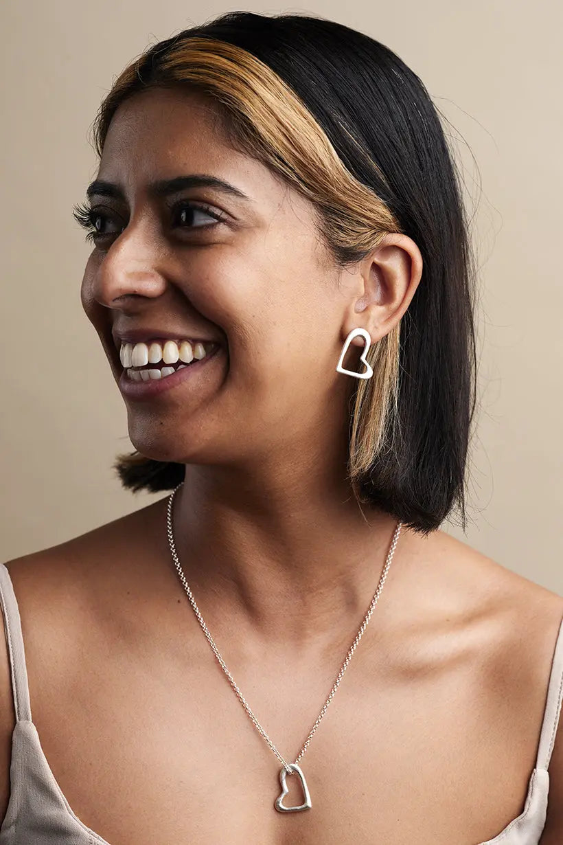 Heartline Necklace in silver, shown worn on model – romantic open-heart pendant from the Petal Hearts Collection