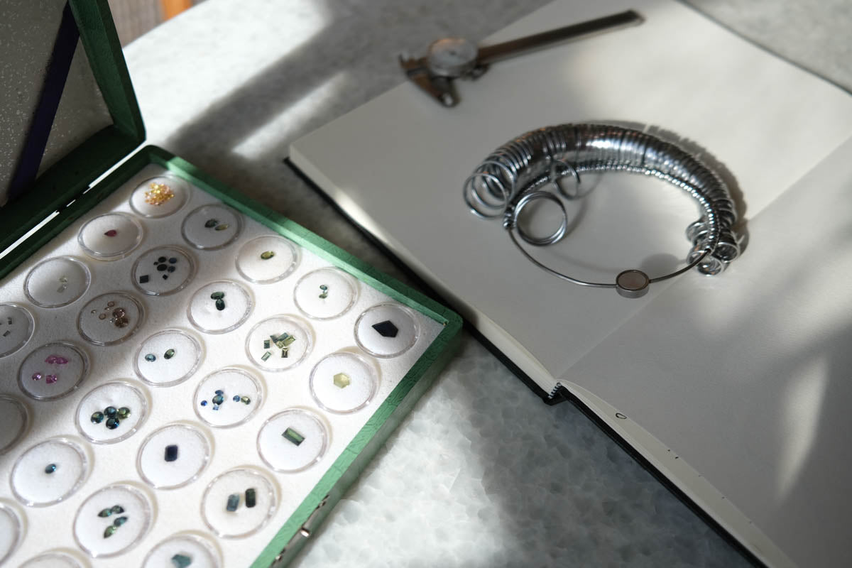 Jewelry display with gemstones and a silver bracelet on a white surface.