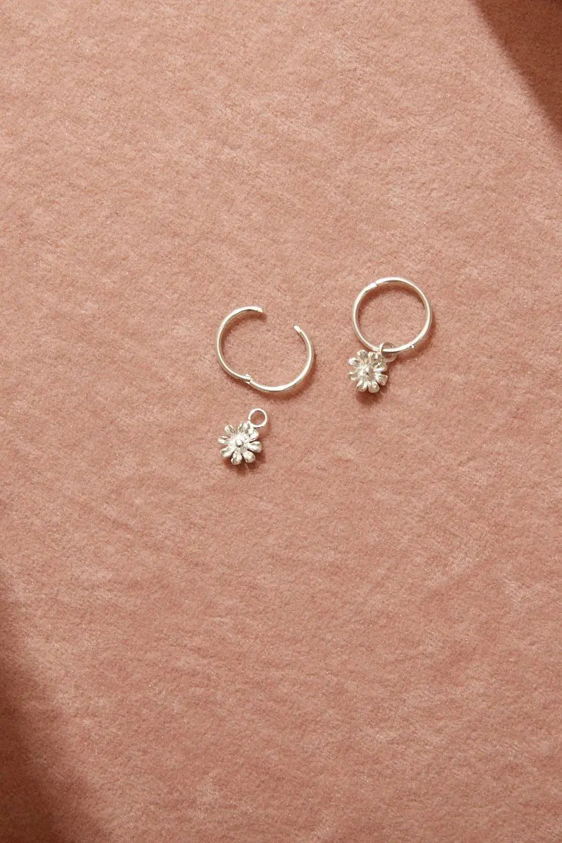 Close-up flatlay of Daisy Sleepers with gentle shadows – highlighting their light-catching texture. One sleeper is open showcasing how the earrings work.