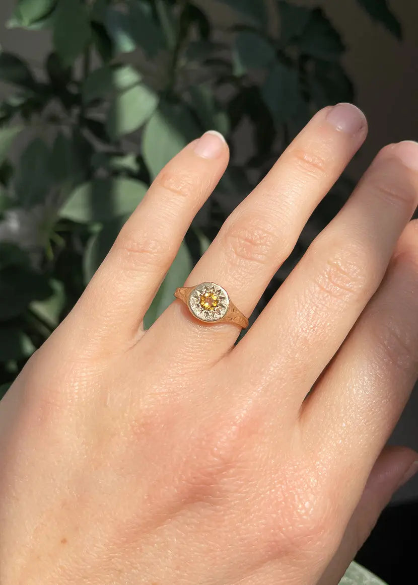 Gold Floral Relic Signet Ring worn on hand in natural light