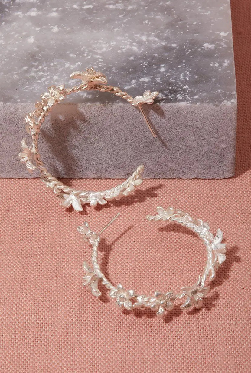 Sterling silver garland hoops on pink linen and grey marble flatly