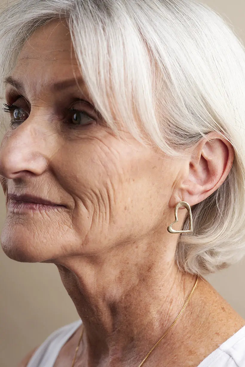 Model wearing 9ct gold Heartline Earrings – romantic heart-shaped studs, handcrafted fine jewellery made in Australia