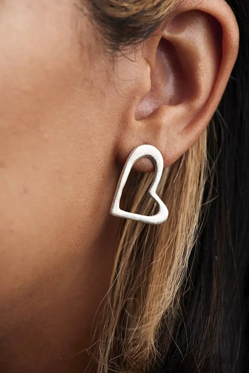 terling silver Heartline Earrings worn on model – handmade open-heart stud earrings inspired by petals and connection