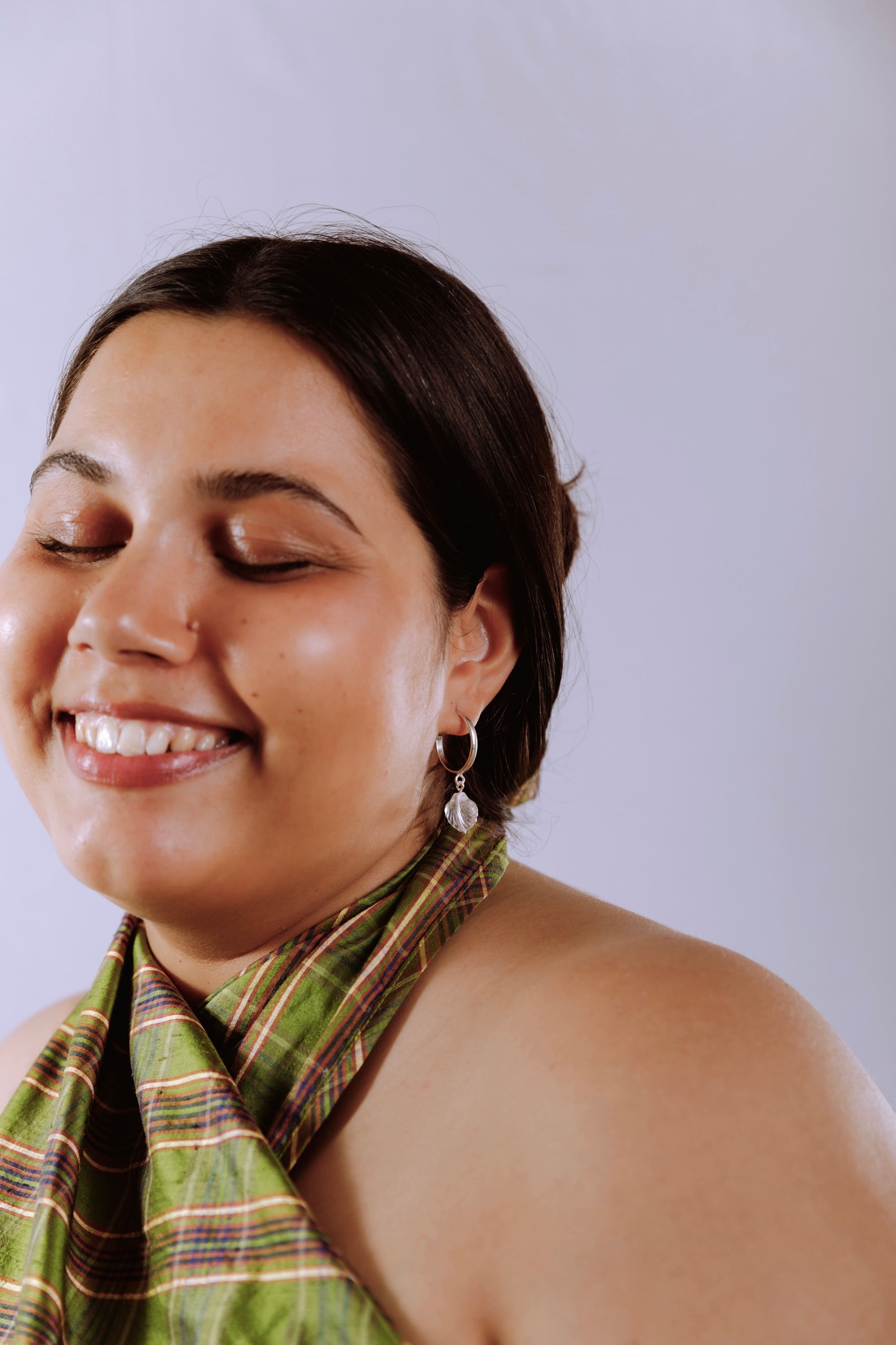 Woman wearing seashell hoops, glass seashell on steering silver