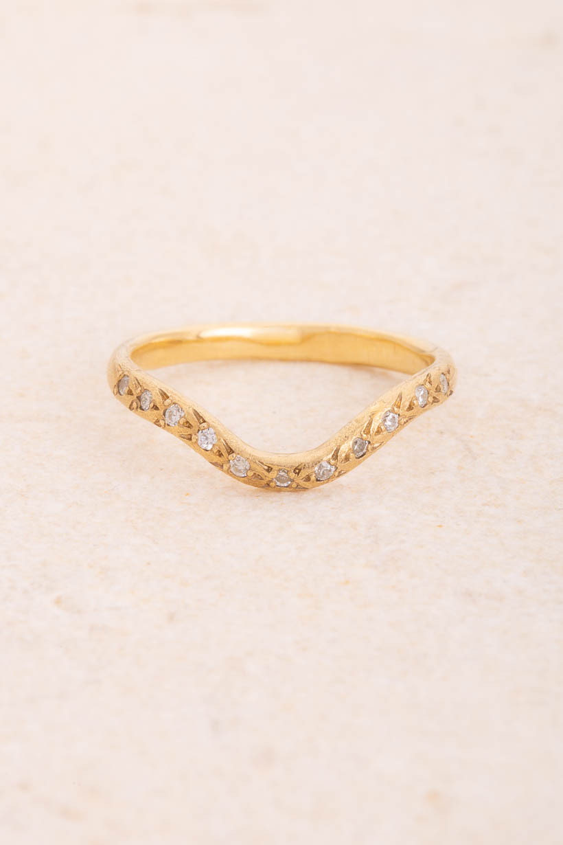Curved Rosette wedding band with eleven natural white diamonds in rosette settings, handmade in Melbourne from recycled gold, front view on limestone