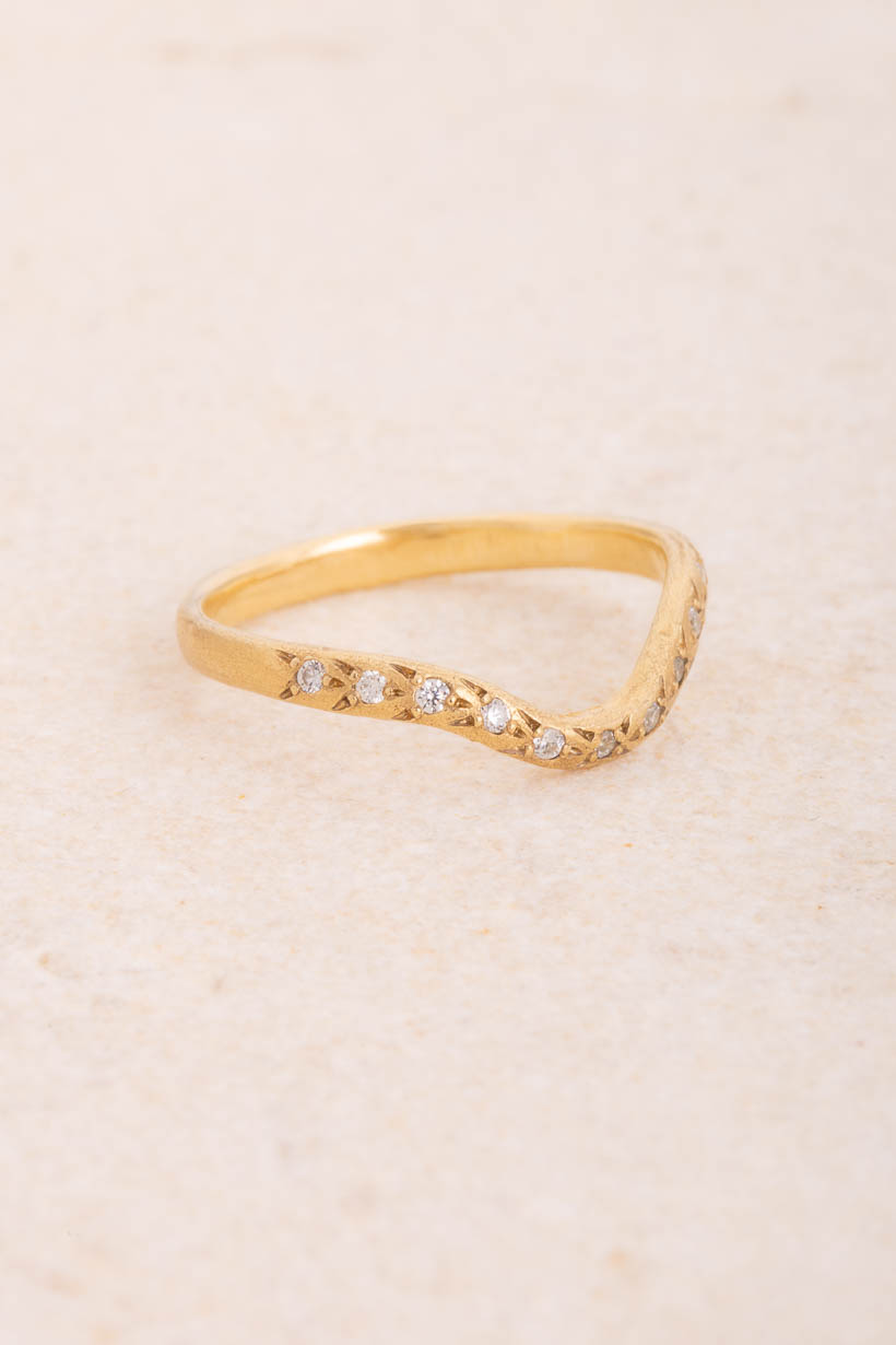Side view of the Curved Rosette diamond wedding band showing the gentle curve that sits snugly beside an engagement ring