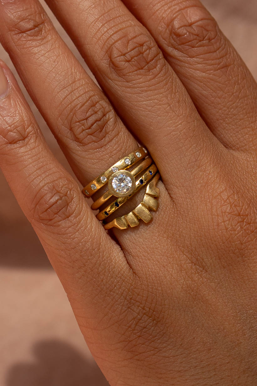 Ring stack on hand: the Dewfall diamond eternity band with the Gumnut solitaire ring, the Rosette ring with deep blue Australian sapphires and the Keystone ring