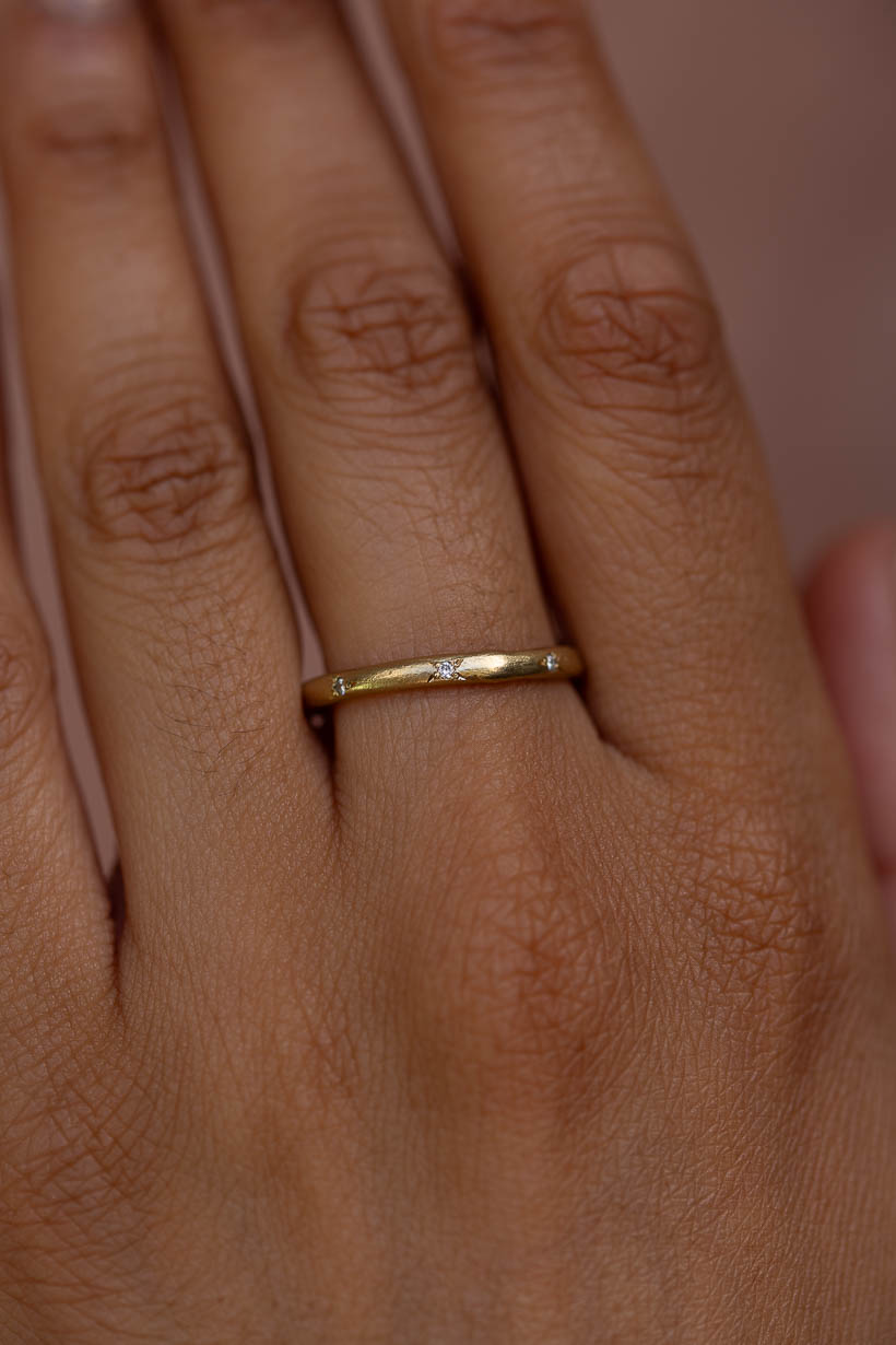 Three diamond Rosette ring worn on the hand, a delicate gold stacking ring handmade in Melbourne by Ada Hodgson