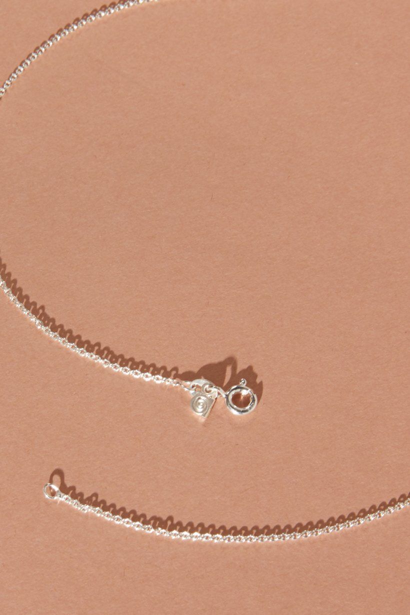 The end of the sterling silver chain showing the ada Hodgson signature tag on the chain