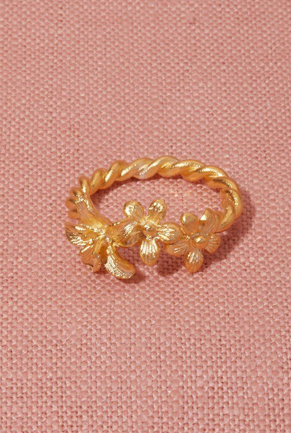 Yellow Gold Garland ring, three wildflowers entwined on a vine, on a pink linen flatlay