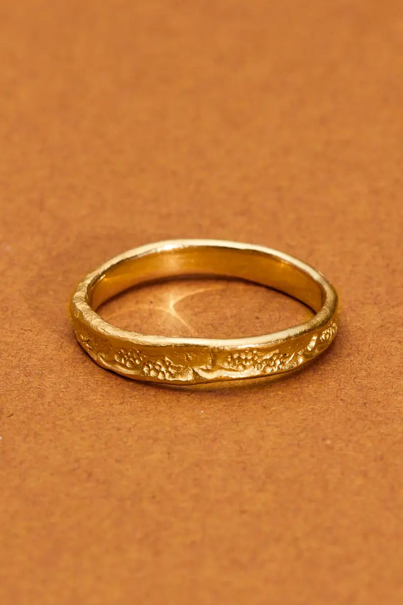 Close-up of Grapevine Ring, a nature inspired gold wedding band, showing detailed vine motif and organic shape