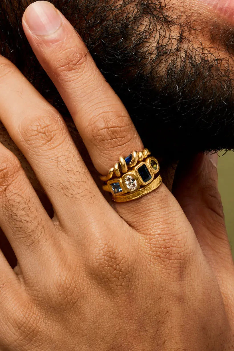 Stack of nature inspired model rings. The twisted vine ring a unique engagement ring with Australian sapphire, Posy ring an alternative engagement ring with diamond, Australian sapphire and Ceylon Sapphire and the Grapevine ring, a textured wedding ring. All worn on a models hand.