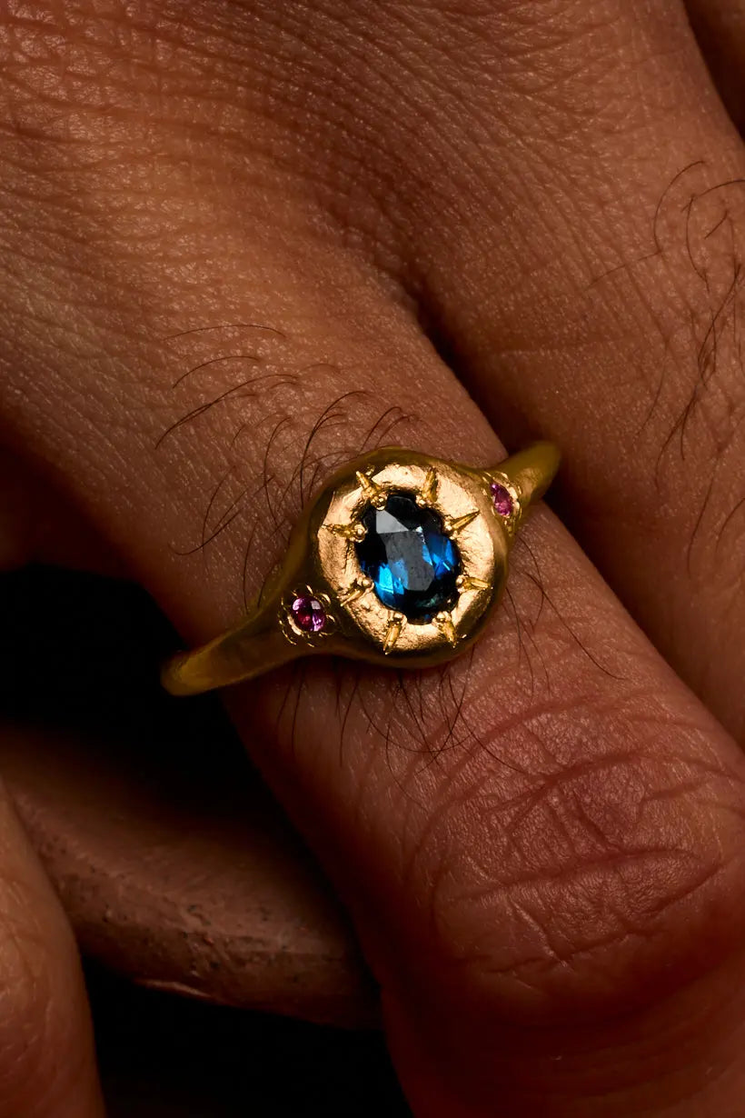 Engraved starburst settings holding Australian and pink sapphires in recycled gold