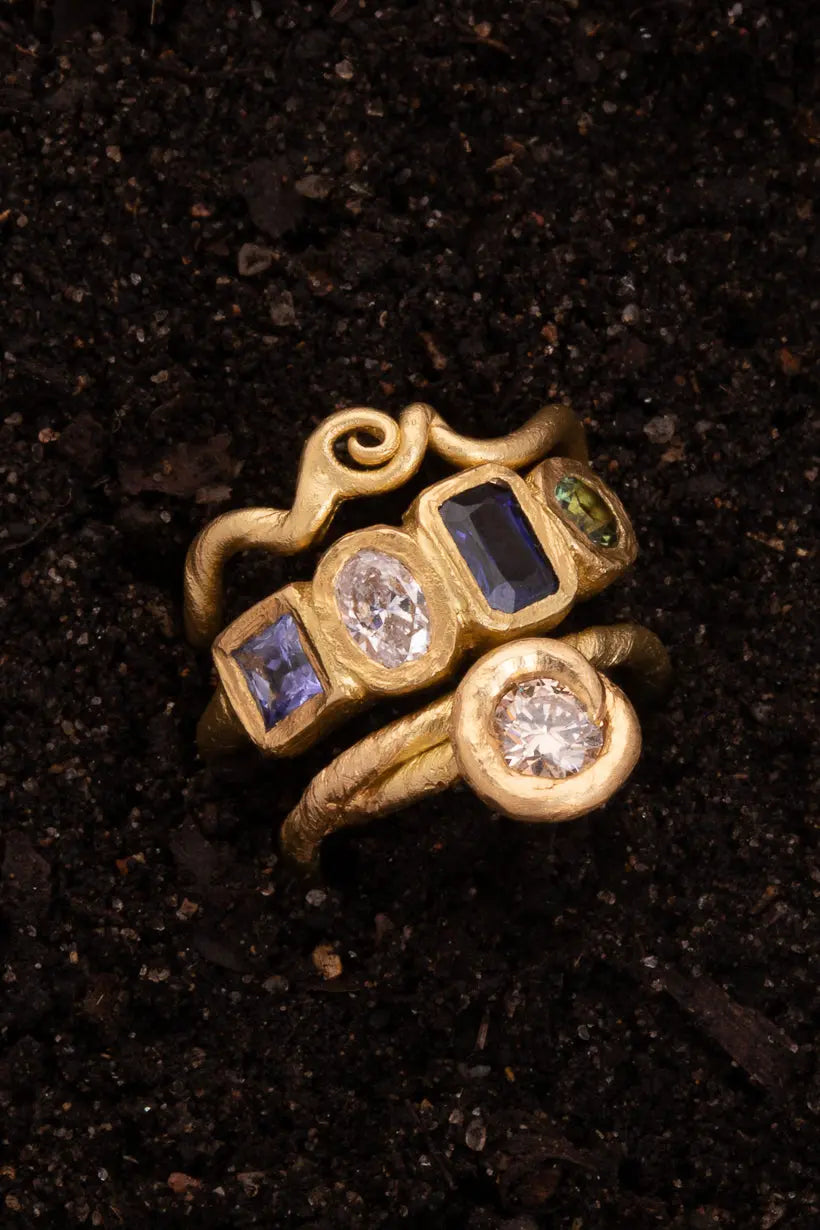 Flat lay of Posy Ring styled with two golden vine rings – handmade alternative engagement rings