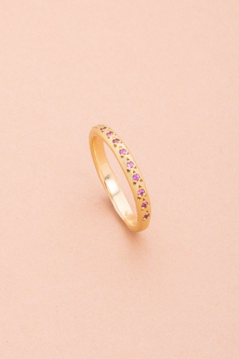 Side angle of the Rosette Ring showing the rosette settings holding each pink sapphire