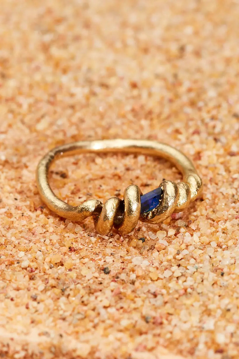 Close-up of Vine Ring with textured gold vines wrapping sapphire