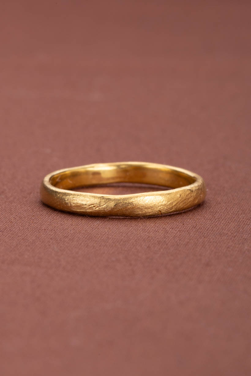 Textured gold ring on a brown textured background