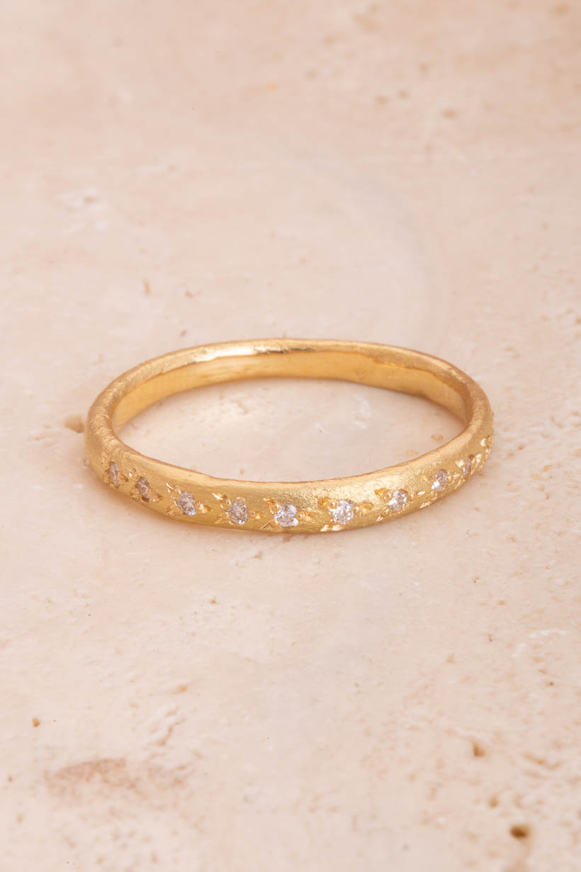 Rosette Ring with 11 white diamonds, flatlay on stone background