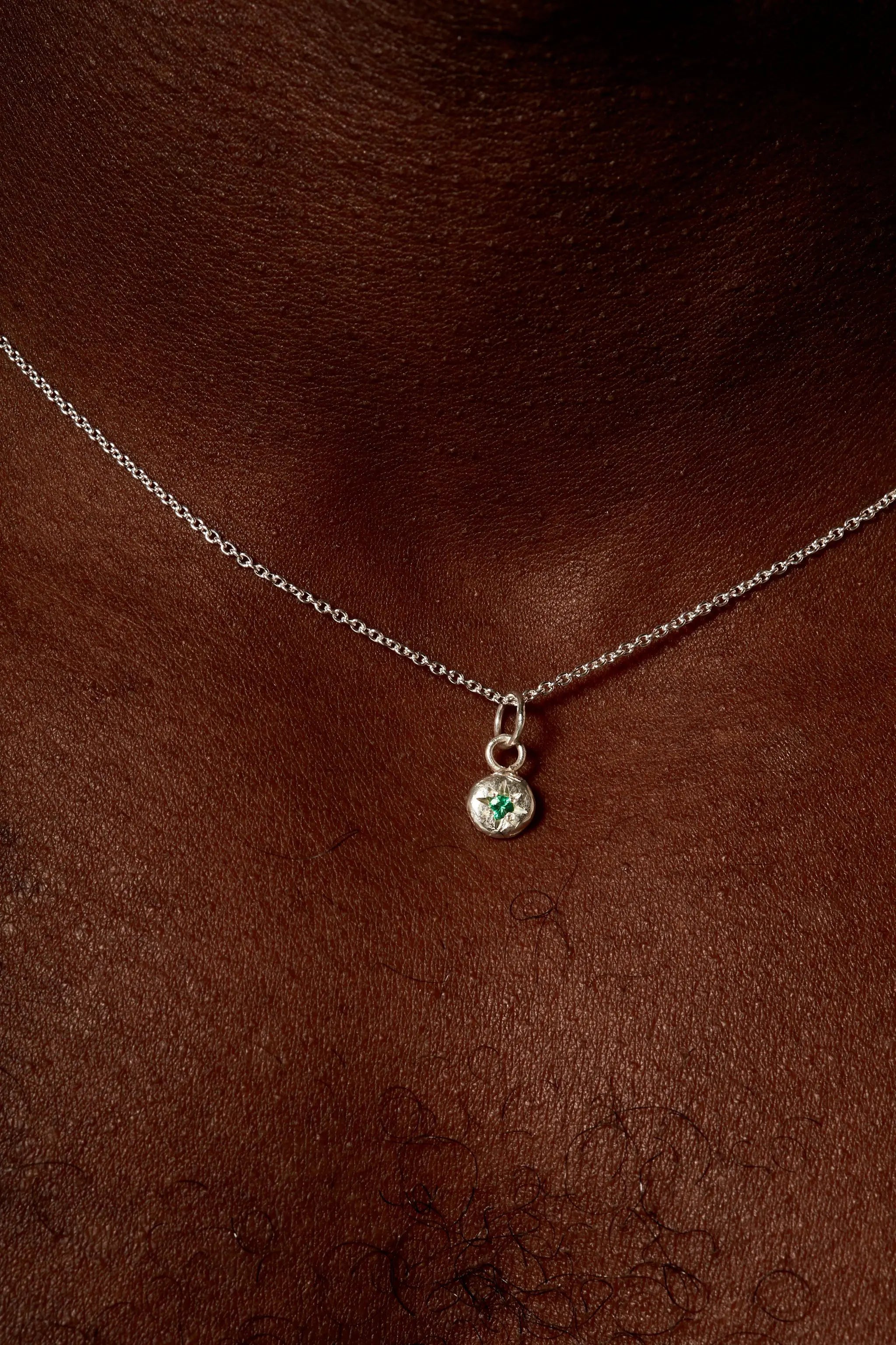 Sterling silver May birthstone necklace with emerald on model