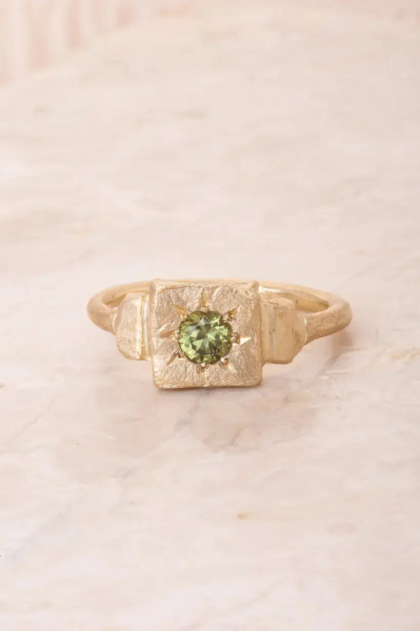 A perfectly imperfect square shaped gold signet ring star set with a vibrant green australian sapphire. 