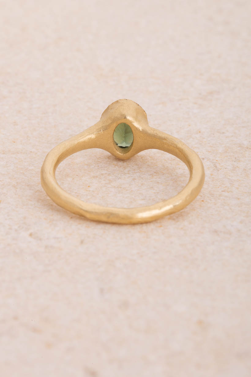 Back view of the Bower green sapphire engagement ring showing the hand-formed bezel rising from the textured recycled gold band