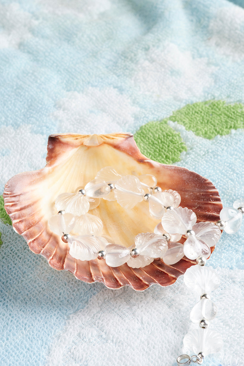 Shell with a necklace on a textured surface