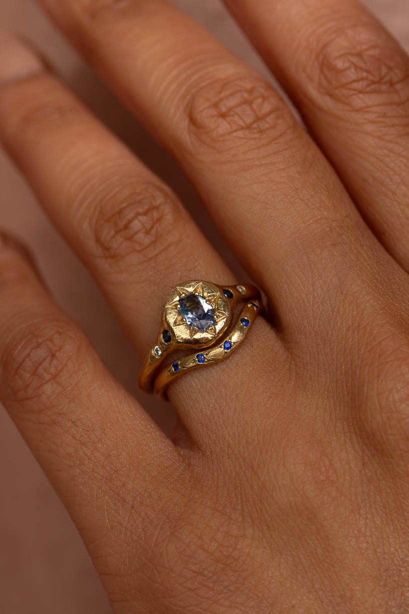 A close up of the Monet's Garden Ceylon sapphire engagement ring stacked with the curved rosette wedding ring with blue Australian sapphires