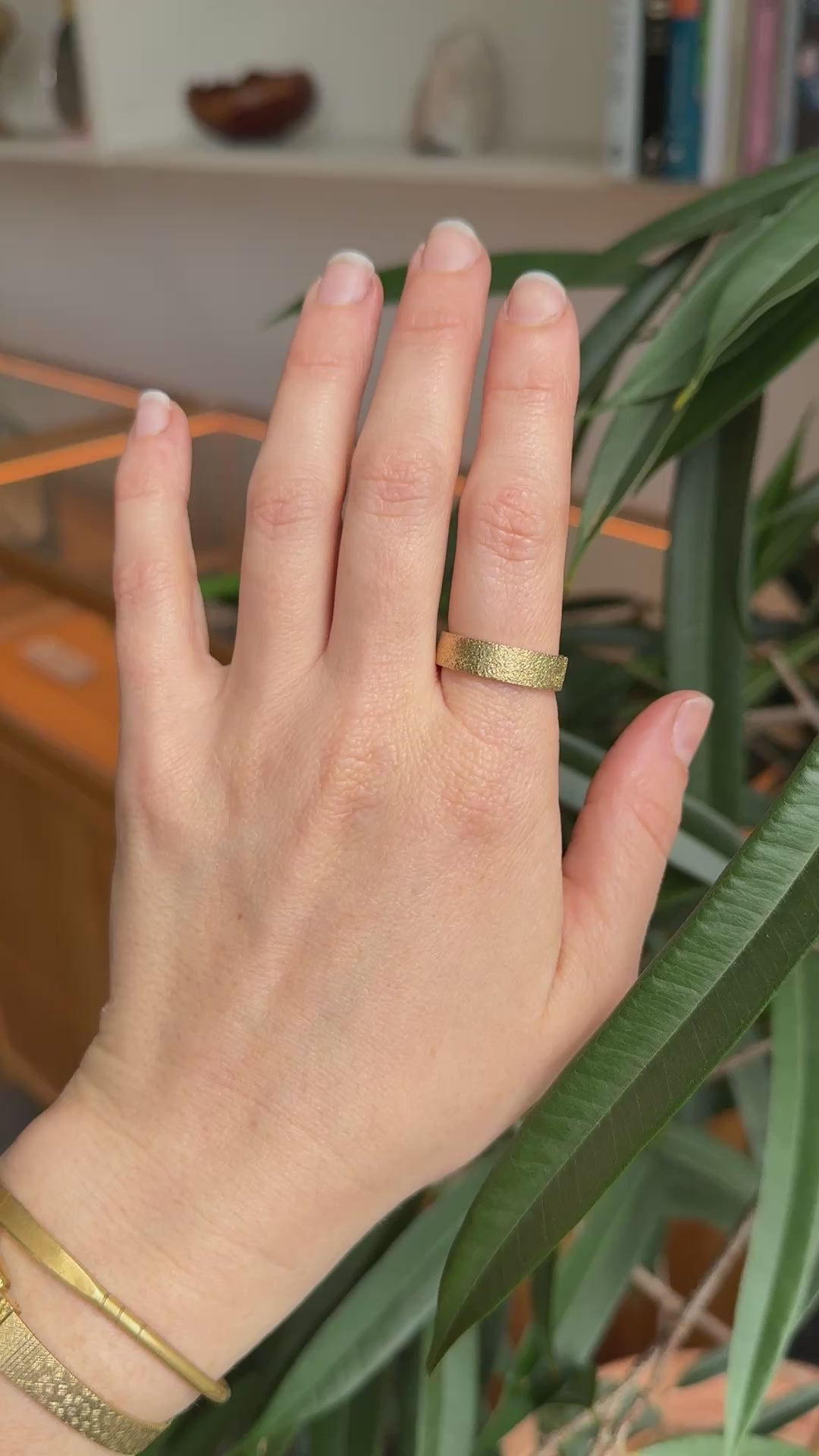 Textured gold wedding ring on models hand