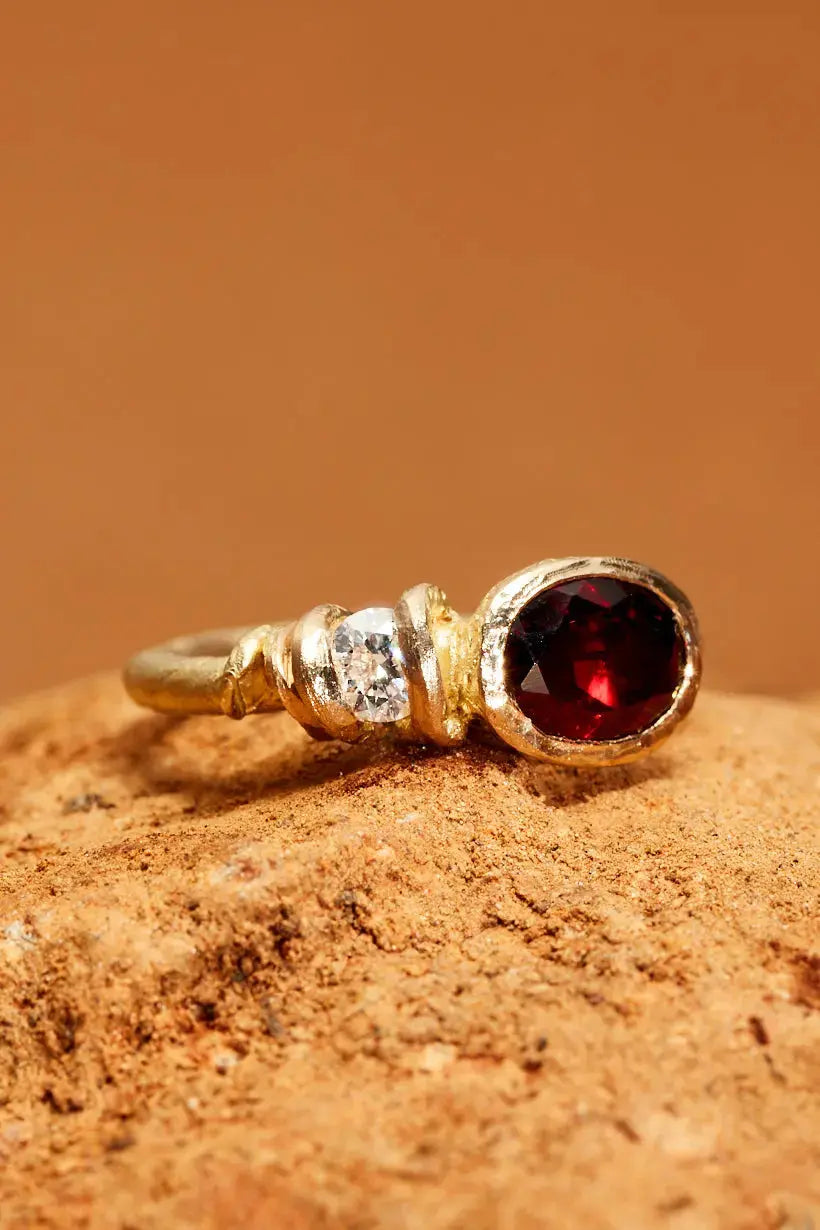 Bramble Ring with deep red garnet and white diamond in textured gold flatlay