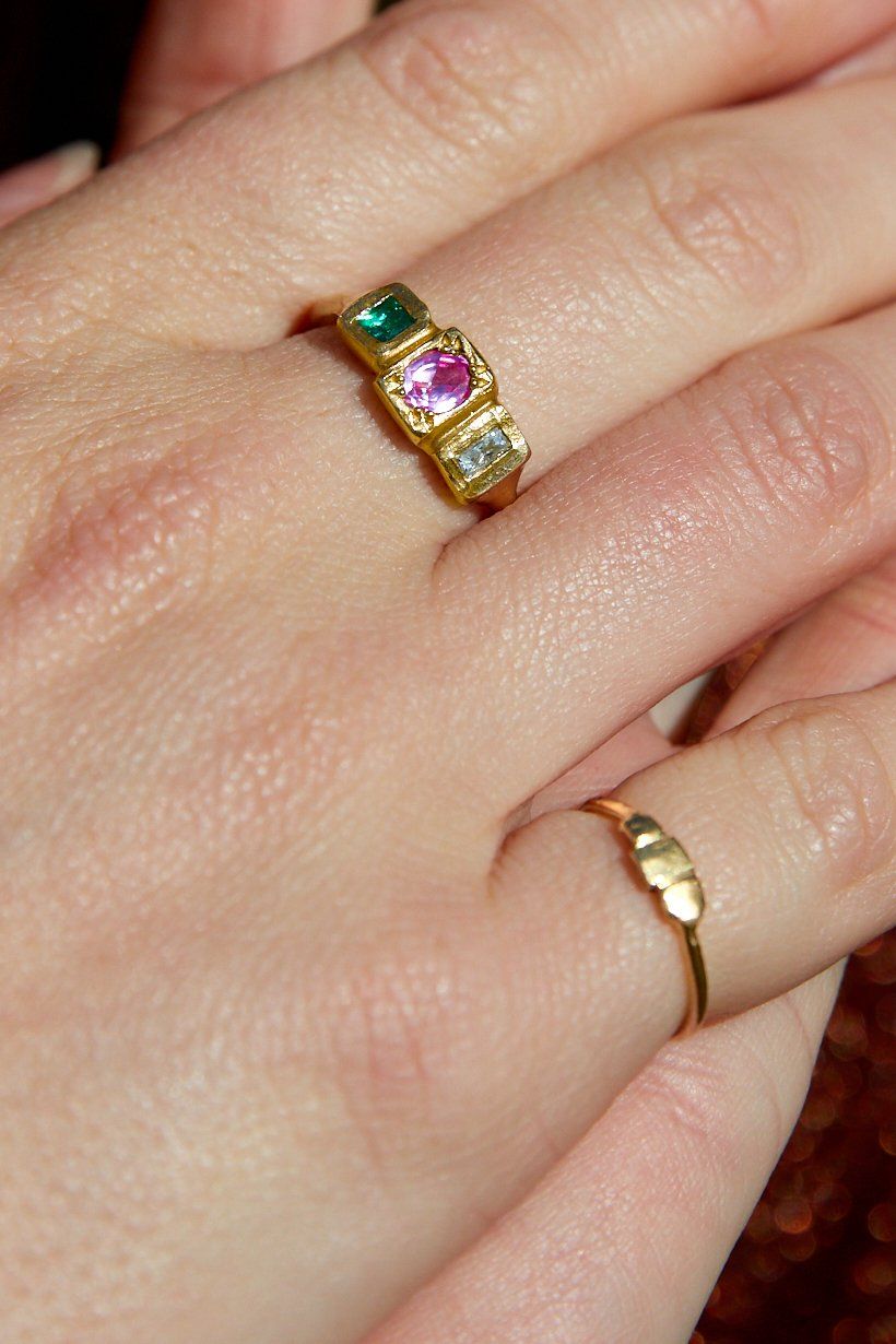 Tile ring in gold catching the golden light, worn on models hand with the Stepping Stones Ring. 