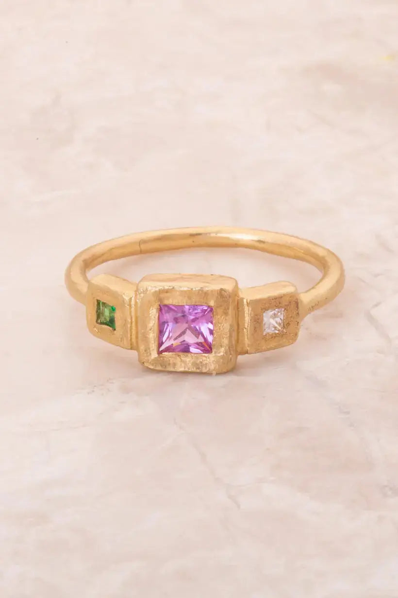 Spring Ring flatlay with pink sapphire, diamond, and tsavorite set in hammered gold