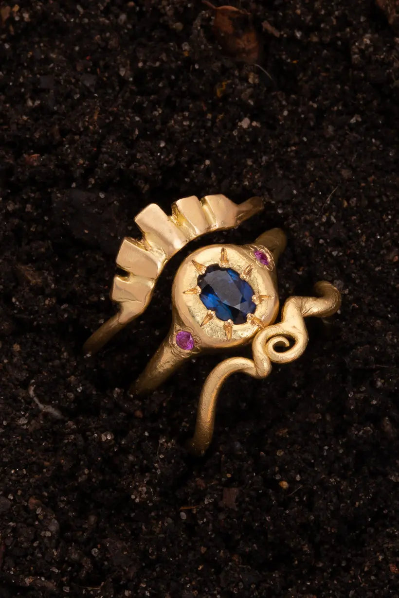 Tendril ring sitting in soil, with the monets garden ring and Keystone ring, a garden inspired stack sprouting form the ground. 