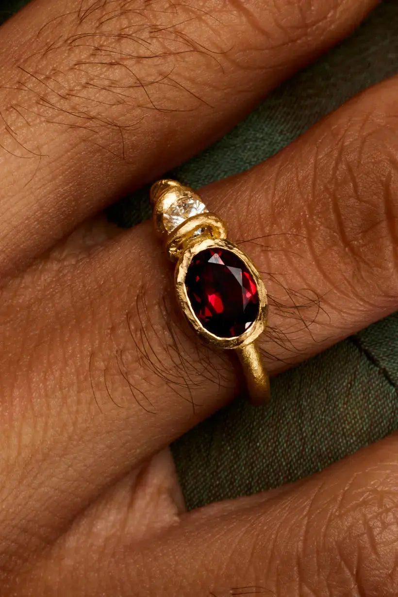 Close-up of Bramble Ring with almandine garnet and white diamond in golden vines